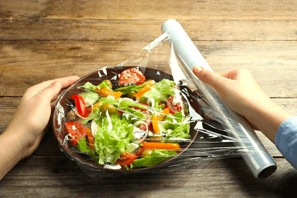 woman_putting_plastic_food_wrap_600nw_2115486509